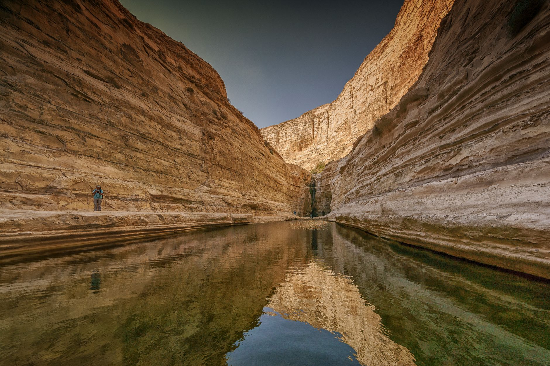 Turquoise wadi pool between canyon walls